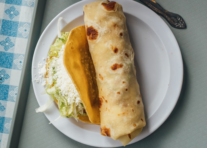 A burrito on a plate at Las Cuatro Milpas.